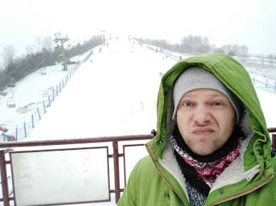 Greg guia em Varsovia, no inverno, com neve e pista de esqui no fundo